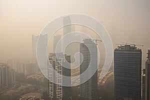 close-up of smoggy city skyline, with the tall buildings fading into the haze