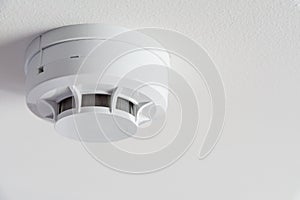 Close up smoke detector on a ceiling.