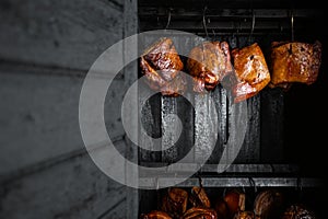 Close up of a smoked meat and belly or beech meat with dark crust in the smokehouse or smoker, food concept