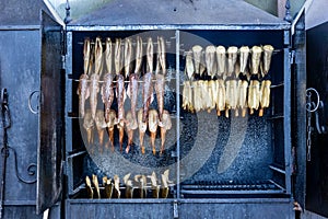 Close up of smokers or roasting ovens with different types of fish being smoked