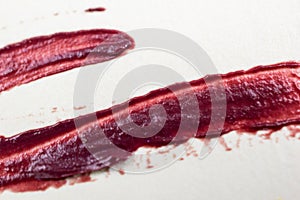 close up of a smudged lipstick on white paper background