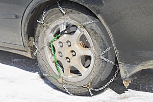 Close-up of snow chains on tires on a winter road