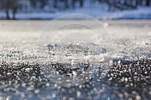 Close-up of snow flakes on the clear first ice on the river