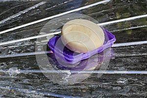 Close-up of the soap, placed on a stainless steel floor with a dirty class