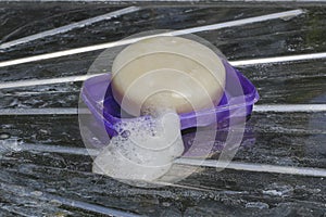 The close-up of the soap and the soap bubble is placed on the sink`s stainless steel floor with dirty layers