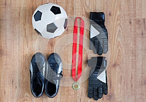 Close up of soccer ball, boots, gloves and medal