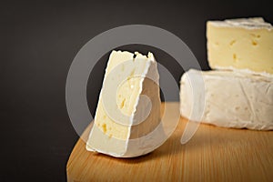 Close-up of Soft French Brie cheese cuts served on wooden board