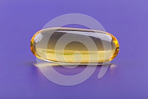 Close up a soft gel capsule on purple background, natural fish o