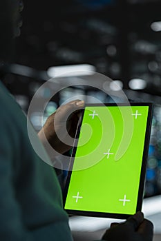Close up of software developer in data center using green screen tablet