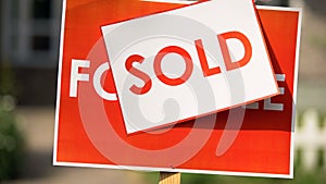 Close-up sold paper installing on for sale signboard, real estate agency, deal