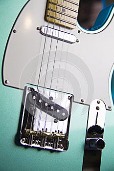 Close up of a solid metallic seafoam green electric guitar