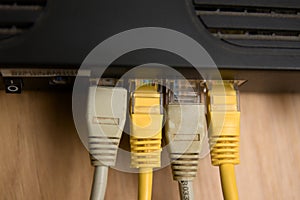 Close-up of some rj45 ethernet type cables connected to a black router
