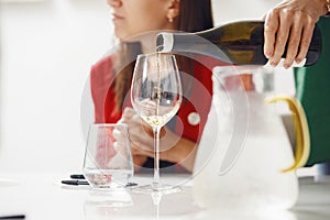 Close-up of sommelier pouring white wine into wine glass. Training and wine tasting.