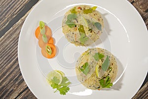 Close up of South Indain breakfast Upma, uppumavu or uppittu on plates with Vegetables