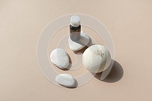 Close up spa aromatherapy composition with cosmetic cream glass and pebbles on beige background.