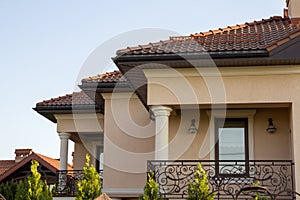 Close up of spacious brown shingle roof of modern luxurious expensive residential cottage house with three chimneys, big windows