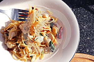 Spaghetti with dried chili, garlic and crab in white dish.