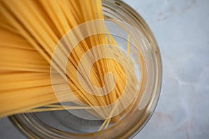 Close-up spaghetti in glass jar. Ingredient for Italian pasta. Raw food