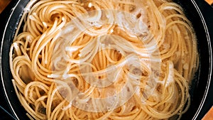 Close-up of spaghetti pasta In boiling hot water in steel pan. Preparation for making Al Dente Spaghetti photo