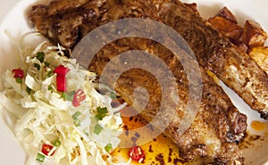 A close up spare ribs with salad and fried potato