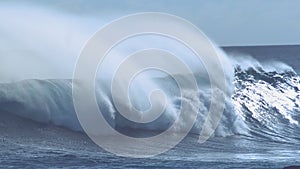 CLOSE UP: Sparkling drops of water fly in the air around breaking tube wave.