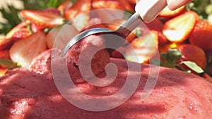 Close-up of the special ice-cream spoon scooping a fresh strawberry ice cream