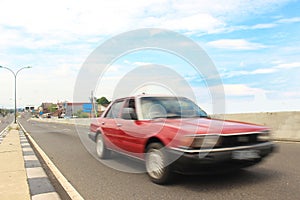 Close-up of speedy on red car on road.