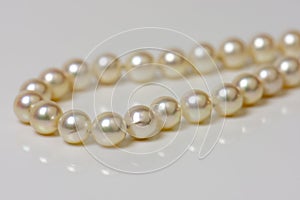 Close up of sphere natural pearl necklace on white background. Selective focus.