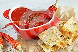 Close-up of a spicy tomato soup with chips