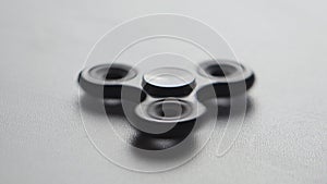 Close up spinner or fidgeting hand toy rotating on white background
