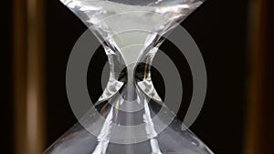 Close Up of Spinning Hourglass and Falling White Sand