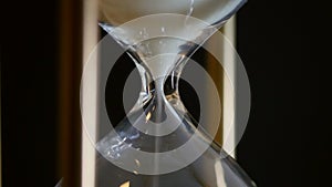 Close Up of Spinning Hourglass and Falling White Sand Counting Down to the Deadline