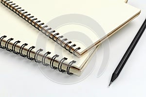 Close up spiral notebook and black pencil on white background for mockup template