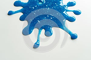 Close up Splash out of Blue Slime Stretching and Mucilage on White Table photo