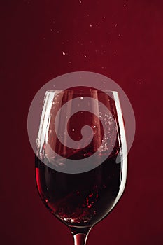 close up of splash of red wine in glass