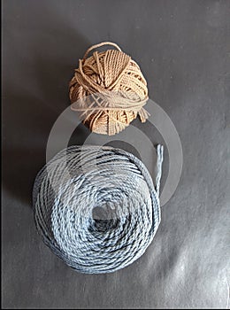 Close up of spools of blue and green threads on black background.