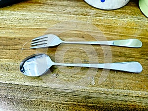 Close up spoon and fork on the wooden table