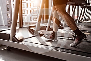 Close up of sport man running on treadmill in fitness gym at condominium in urban. People lifestyles and sport activity concept