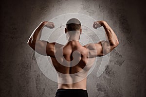 Close up of sportive man's body over dark background.