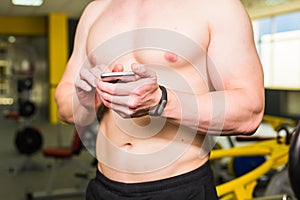 Close-up of Sportive Man After Workout Session Checks Fitness Results Smartphone. Sport Tracker Wristband Arm.Training