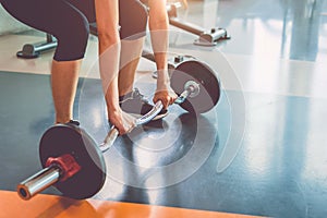 Close up of sports woman lifting weight in fitness gym. Workout exercise and Body build up concept. Barbell lifting and healthy photo