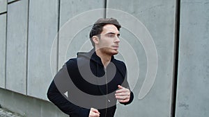 Close up sportsman running outdoor. Handsome guy running upstairs in slow motion