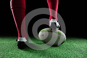 Close up of sportsperson stepping on rugby ball