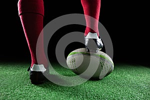 Close up of sportsperson stepping on rugby ball photo