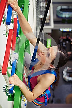 Close-up of sportswoman climbing in indoor rock-climbing center