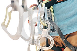 Close-up of sportswoman in harness with mountaineering equipment.