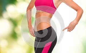 Close up of sporty woman pointing at her buttocks