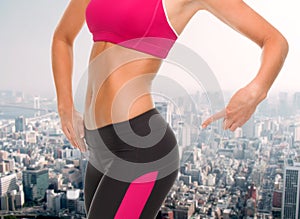 Close up of sporty woman pointing at her buttocks