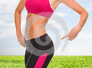 Close up of sporty woman pointing at her buttocks