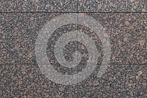 Close-up of spotty maroon and black granite tile